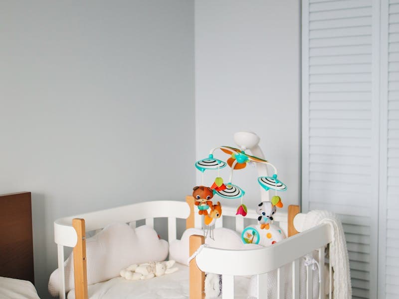 Baby in cot with mobile above